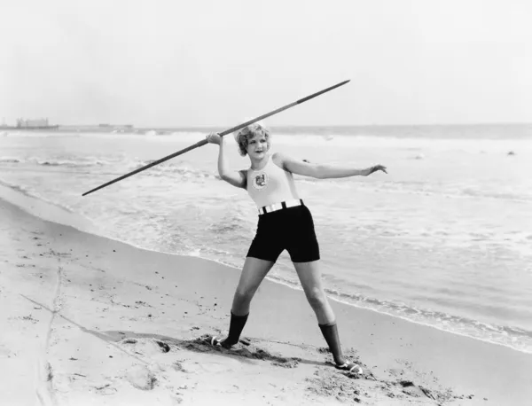若い女性のビーチでやり投げをする準備をして — ストック写真
