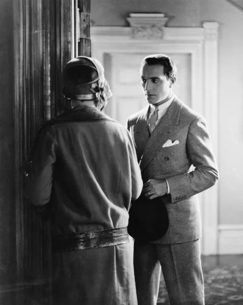 Mężczyzna stojący przed kobieta w drzwiach — Zdjęcie stockowe