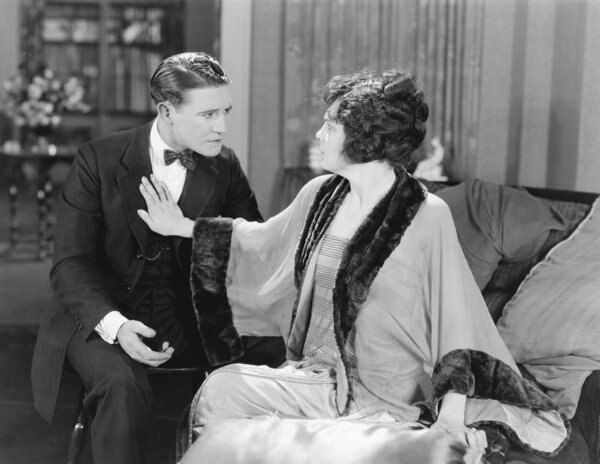 Couple looking at each other while she is pushing him away