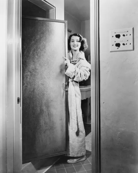 Retrato de una mujer joven de pie en la puerta de un baño —  Fotos de Stock