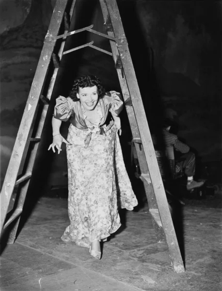 Mulher andando sob uma escada passo com os dedos cruzados — Fotografia de Stock