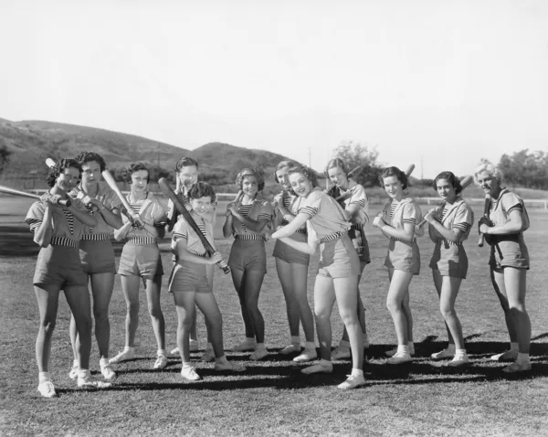 Grupo de mujeres sosteniendo bates de béisbol y de pie en fila — Foto de Stock
