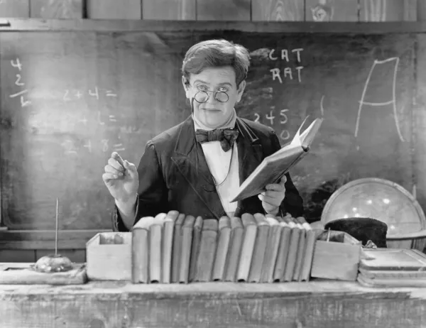 Man with glasses teaching in a classroom — Stock Photo, Image