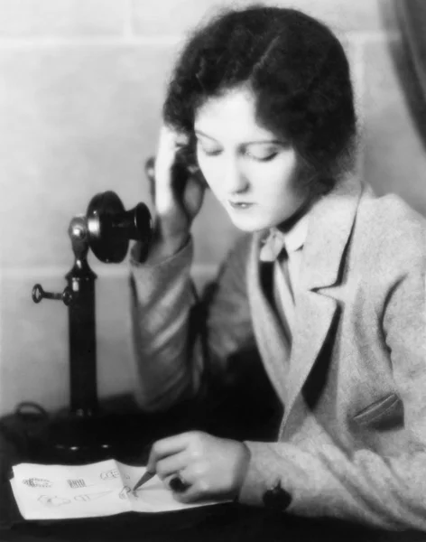 Close-up van een vrouw praten over de telefoon en tekening op een vel papier — Stockfoto