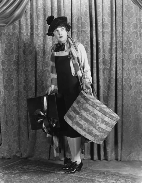 Kobieta w beret przytrzymanie pudełko kapelusz i prezenty — Zdjęcie stockowe