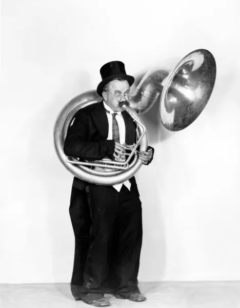 Homme jouant un tuba dans un chapeau haut de forme — Photo