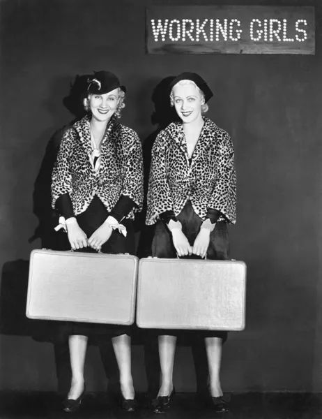 Портрет двух стюардесс, держащих чемоданы и улыбающихся — стоковое фото