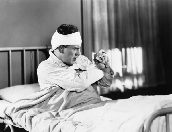Człowiek siedzi na łóżku szpitalnym szuka obawa — Zdjęcie stockowe