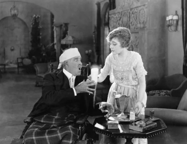 Mujer dando un vaso de poción a un hombre enfermo — Foto de Stock