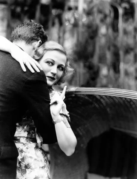 stock image Young woman embracing a man and pointing towards an information board