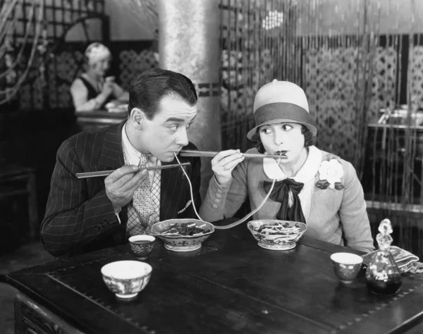 Casal compartilhando um macarrão em um restaurante — Fotografia de Stock