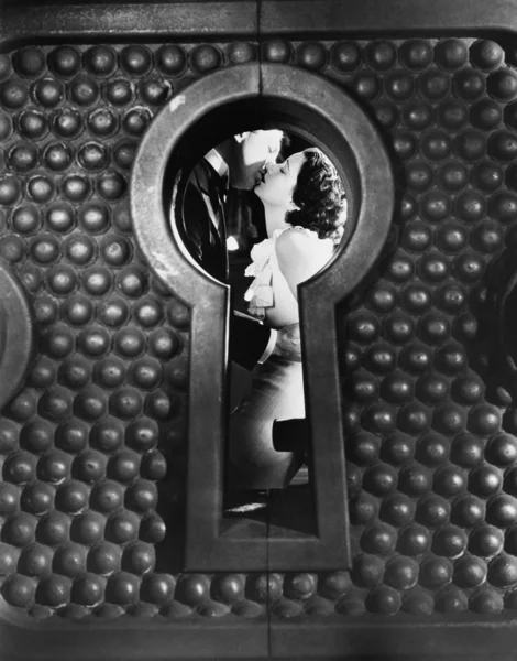 Bild av ett par kyssas sedd genom ett nyckelhål — Stockfoto