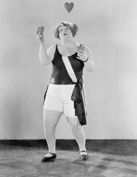 Γυναίκα juggling με σχήμα καρδιάς αντικείμενα — Φωτογραφία Αρχείου