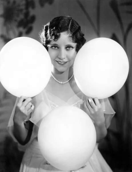 Balonlar elleri ve dizleri üzerinde Dengeleme genç bir kadın portresi — Stok fotoğraf