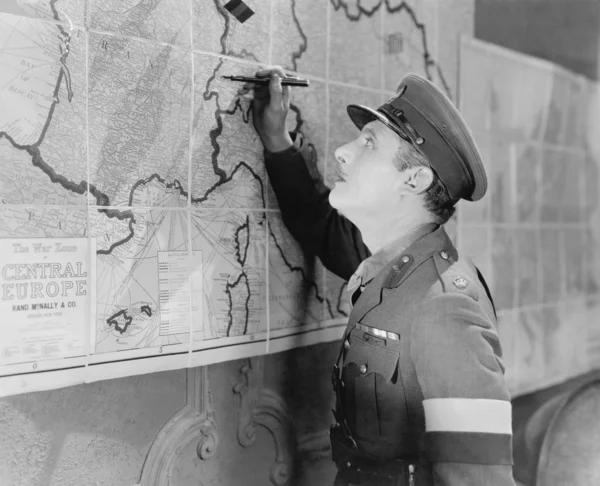 Soldado olhando para um mapa marcando-o com uma caneta — Fotografia de Stock