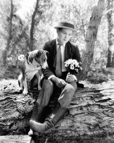 Genç adam ormanda kimsesiz görünümlü köpeğiyle oturuyor — Stok fotoğraf