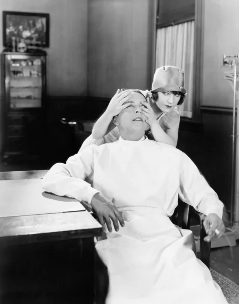 Mujer poniendo sus manos juguetonamente sobre los ojos de los médicos — Foto de Stock