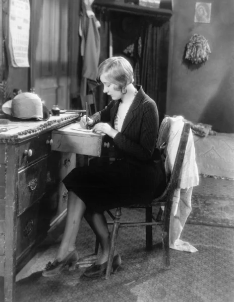 Femme assise à son bureau écrivant une lettre — Photo