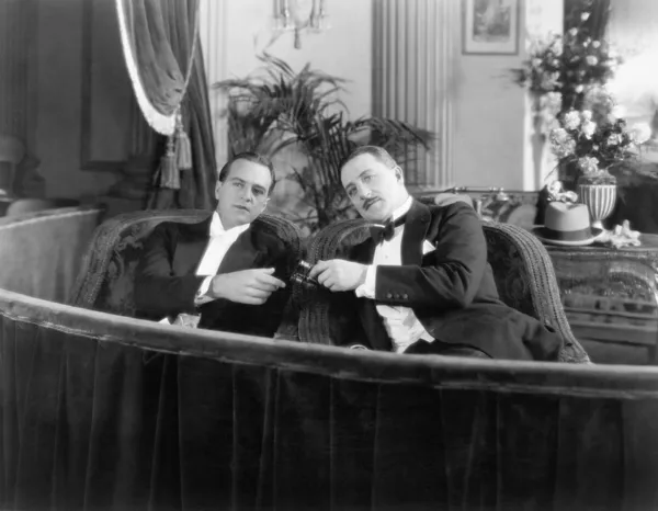 两名男子穿着正式一起坐在一个剧院框 — 图库照片