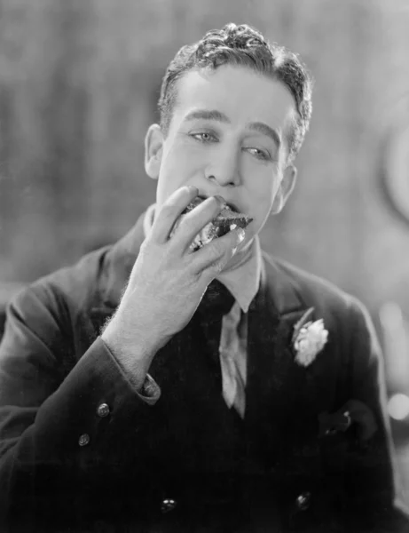 Άνθρωπος με ένα κομμάτι του κέικ στο στόμα του — Φωτογραφία Αρχείου