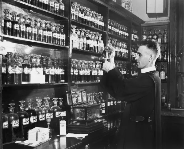 Hombre en una farmacia mezclando medicina — Foto de Stock