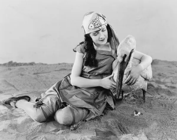 Γυναίκα που κάθεται στο έδαφος επί το χέρι μια πελεκάνος — Φωτογραφία Αρχείου