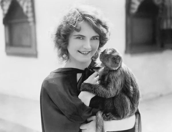 Vrouw met een huisdier aap in haar armen — Stockfoto