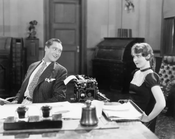 Άνδρα και γυναίκας σε ένα γραφείο που φλερτάρει με το άλλο — Φωτογραφία Αρχείου