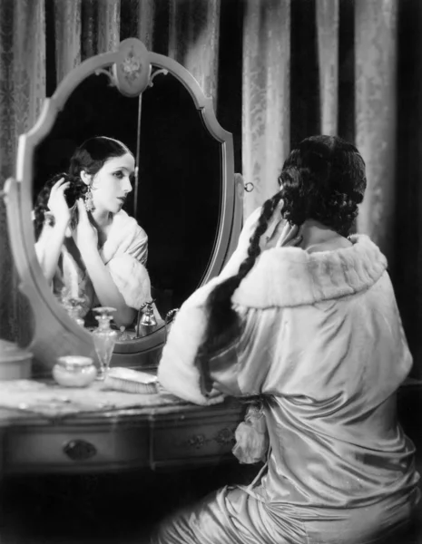 Kadın onun vanity masada uzun saçları sabitleme — Stok fotoğraf