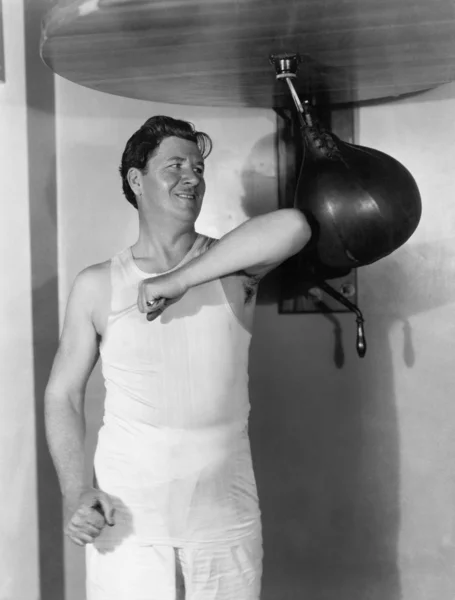 Atleta haciendo ejercicio con un saco de boxeo —  Fotos de Stock