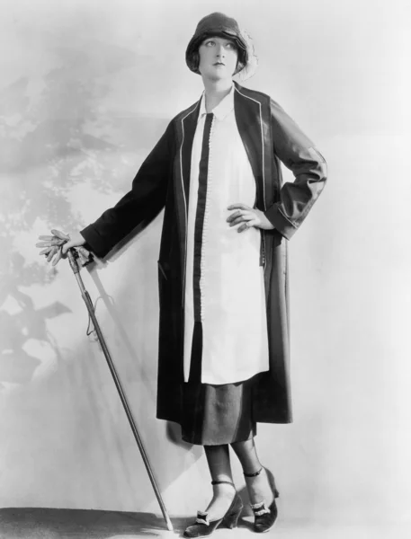 Žena s vycházkovou hůl v elegantní šaty a plášť — Stock fotografie
