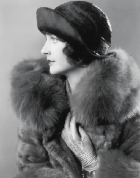 Perfil de uma mulher elegante em um casaco de pele e chapéu de cetim — Fotografia de Stock