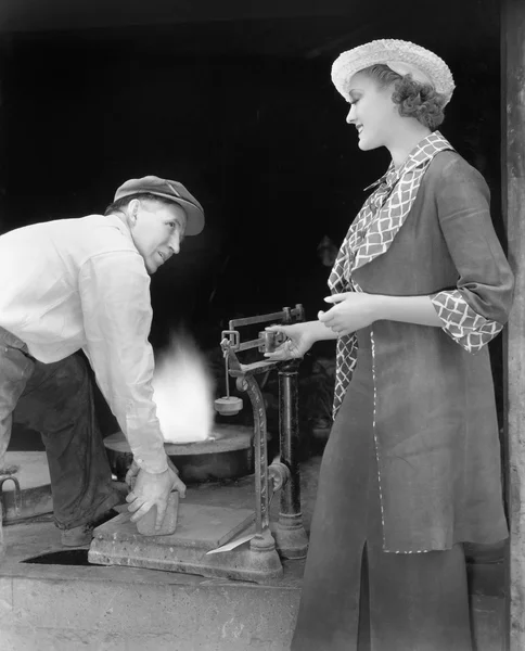 Frau wiegt ein Stück Eisen in einer Gießerei — Stockfoto