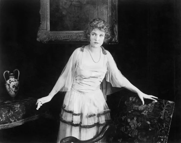 Γυναίκα σε ένα τούλι φόρεμα στέκεται δίπλα σε μια πολυθρόνα — Φωτογραφία Αρχείου