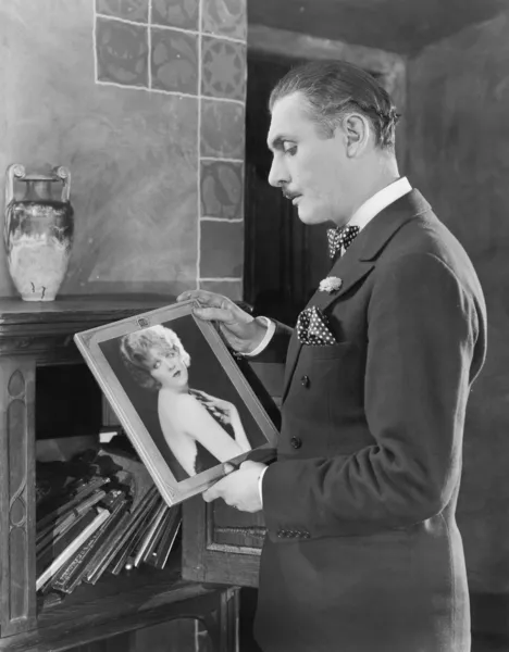 Ο άνθρωπος μελετώντας μια εικόνα μιας γυναίκας — Φωτογραφία Αρχείου