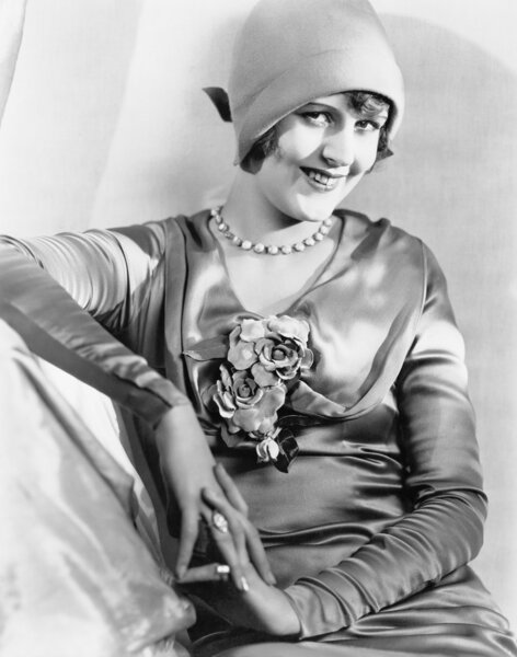 Woman in a cloche hat and satin dress looking vivacious