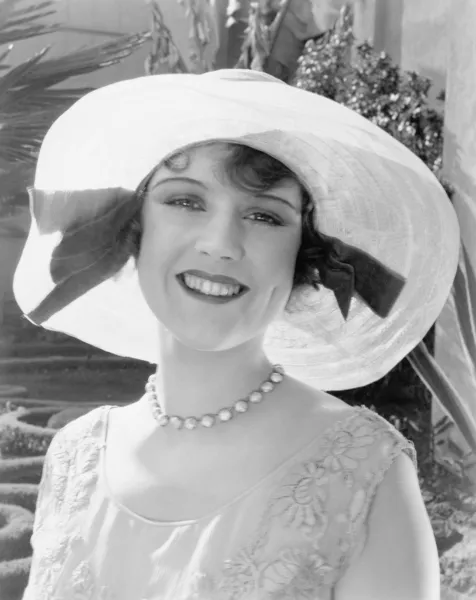 Vrouw in een breed omrande hoed glimlachen — Stockfoto