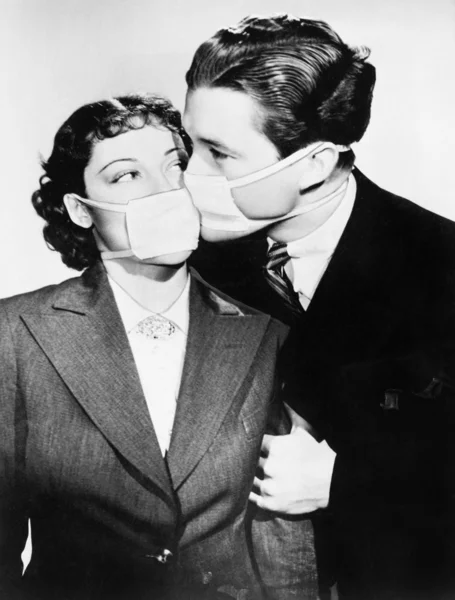 Paar zoenen elkaar met gezondheid maskers — Stockfoto