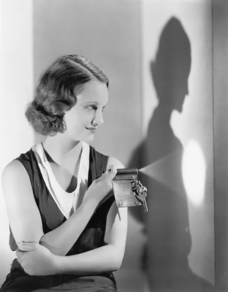 Jovem mulher usando uma lanterna em seu chaveiro — Fotografia de Stock