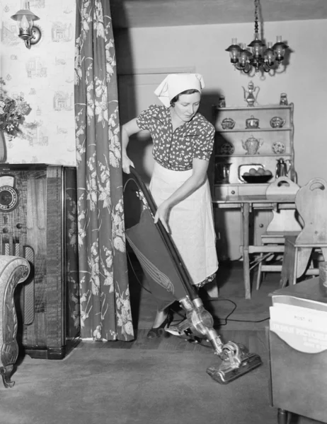 Frau erledigt Hausarbeit mit Staubsauger — Stockfoto