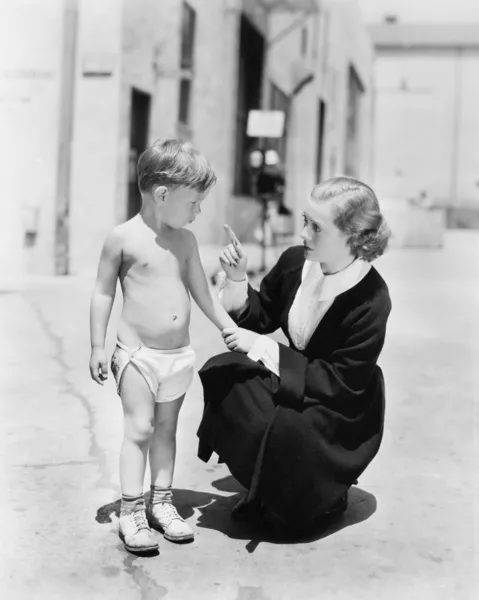 Pequeño niño en pañales siendo regañado por su madre — Foto de Stock
