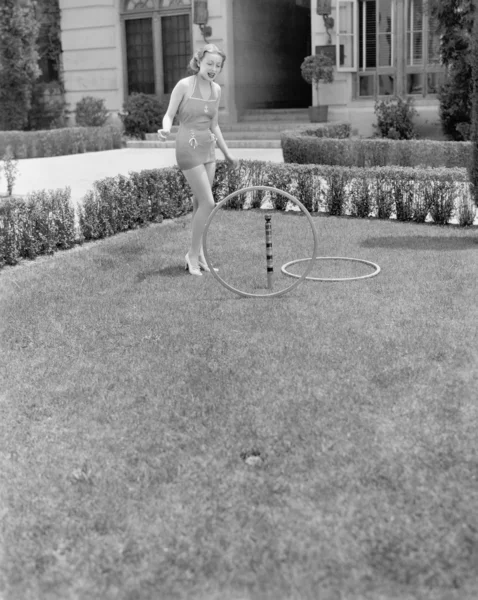 Yüzük bahçede oynayan güneş elbiseli genç kadın — Stok fotoğraf