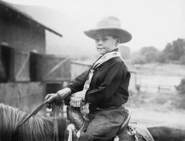 Niño en un sombrero de vaquero en un caballo —  Fotos de Stock