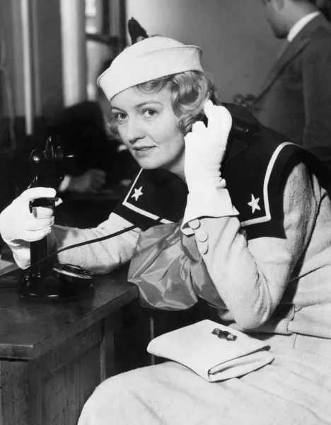Jonge vrouw in een uniform zeilers op de telefoon — Stockfoto