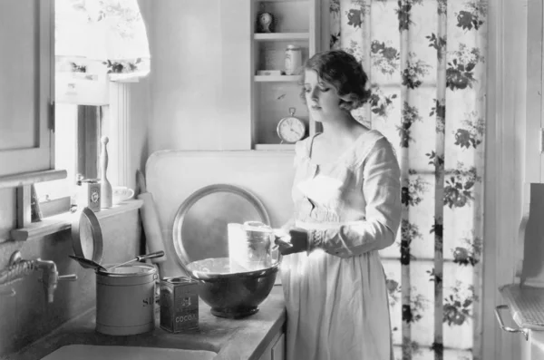 Ung kvinna i hennes kök, bakning — Stockfoto