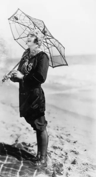 Fiatal nő a tengerparton, egy esernyő, néz ki, mint egy pók hálójában — Stock Fotó