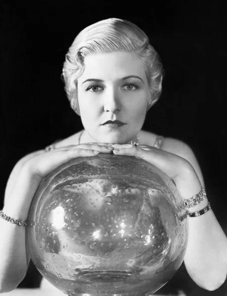 The world might be her oyster, but this young woman seems, leaning on her crystal ball — Stock Photo, Image