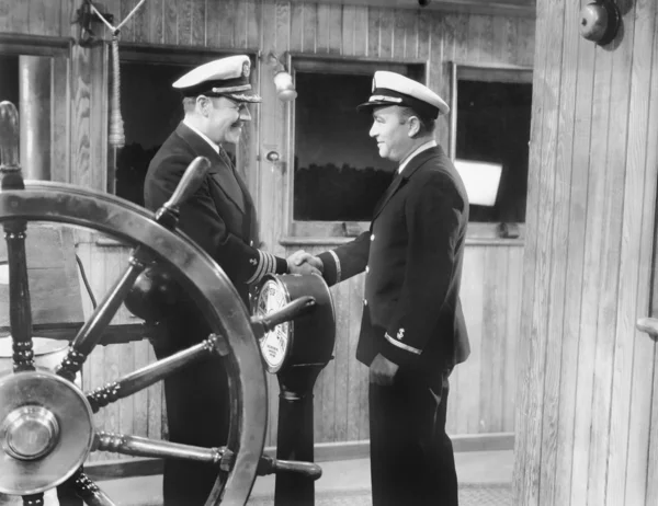 Dois capitães apertando as mãos em um barco — Fotografia de Stock