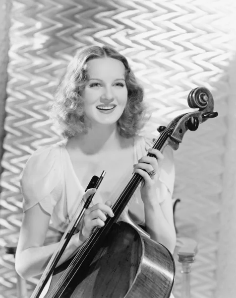 Молодая женщина с бантиком и виолончелью — стоковое фото