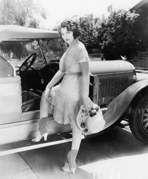 Молодая женщина садится в машину, чтобы покататься в Countr — стоковое фото